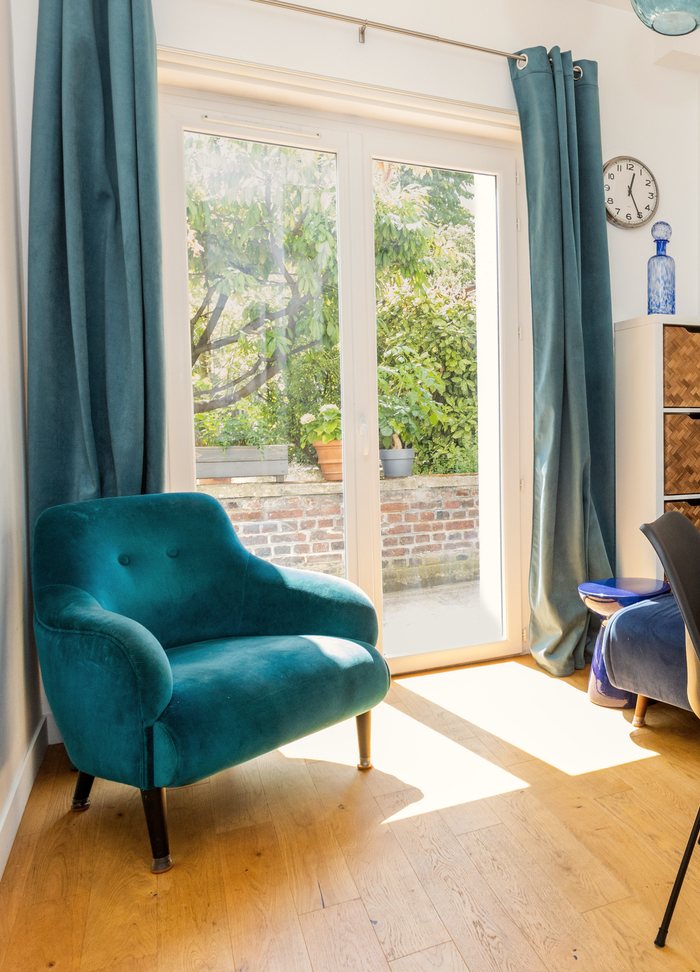 Fauteuil en velours près de la porte-fenêtre, dans le cabinet de sophrologie à Boulogne-Billancourt